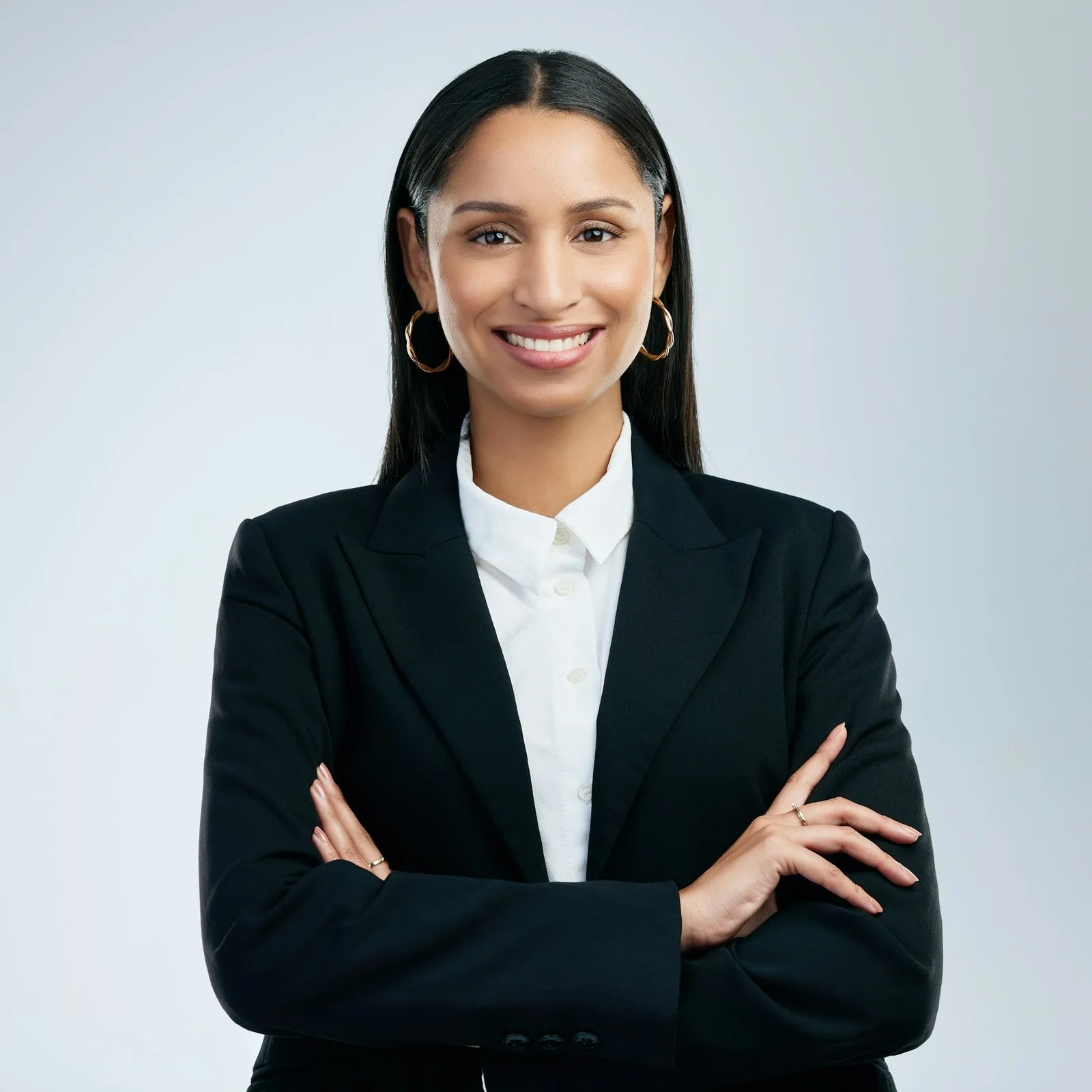 shot of a confident young businesswoman standing against a grey background